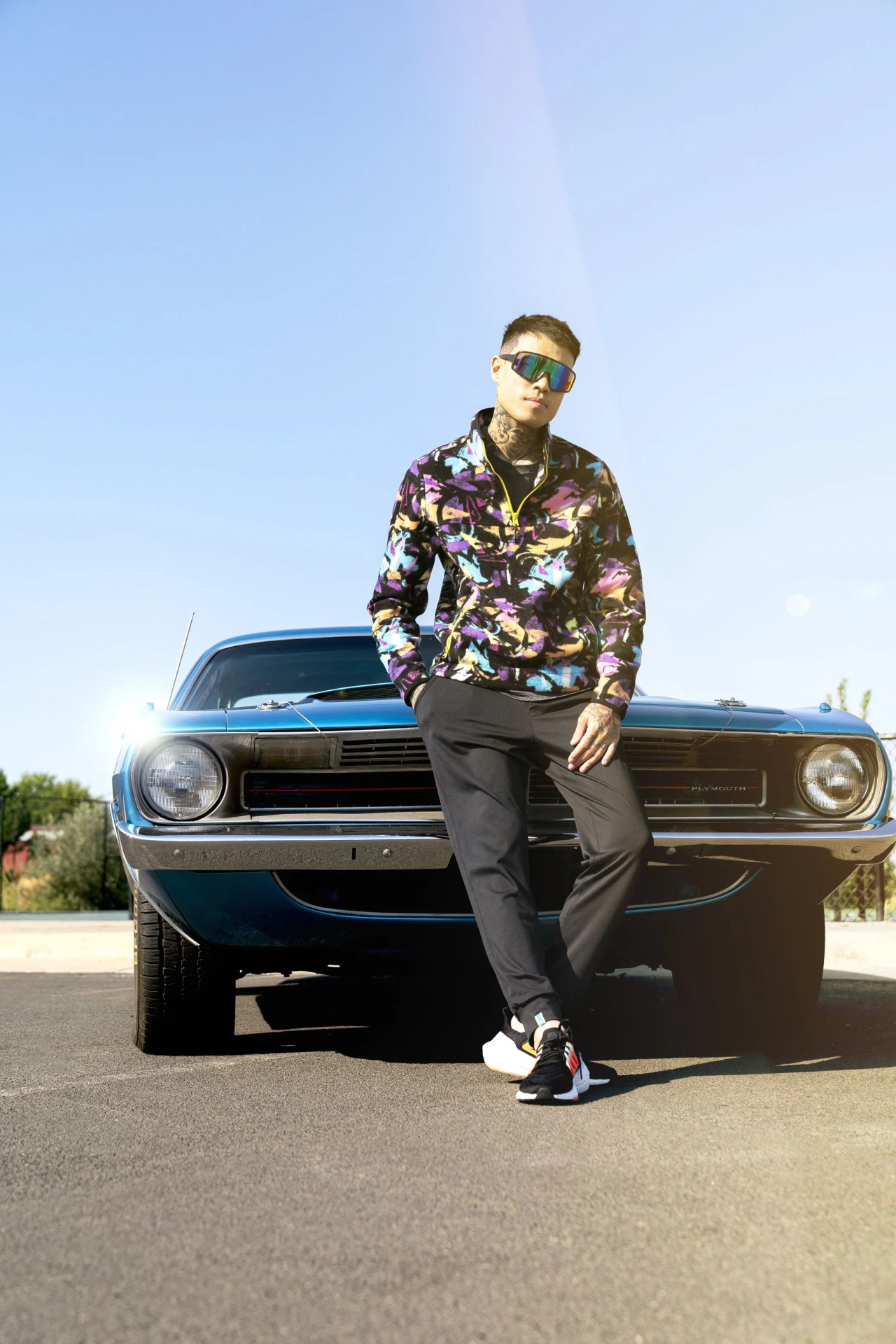 man leaning against a vintage plymouth car