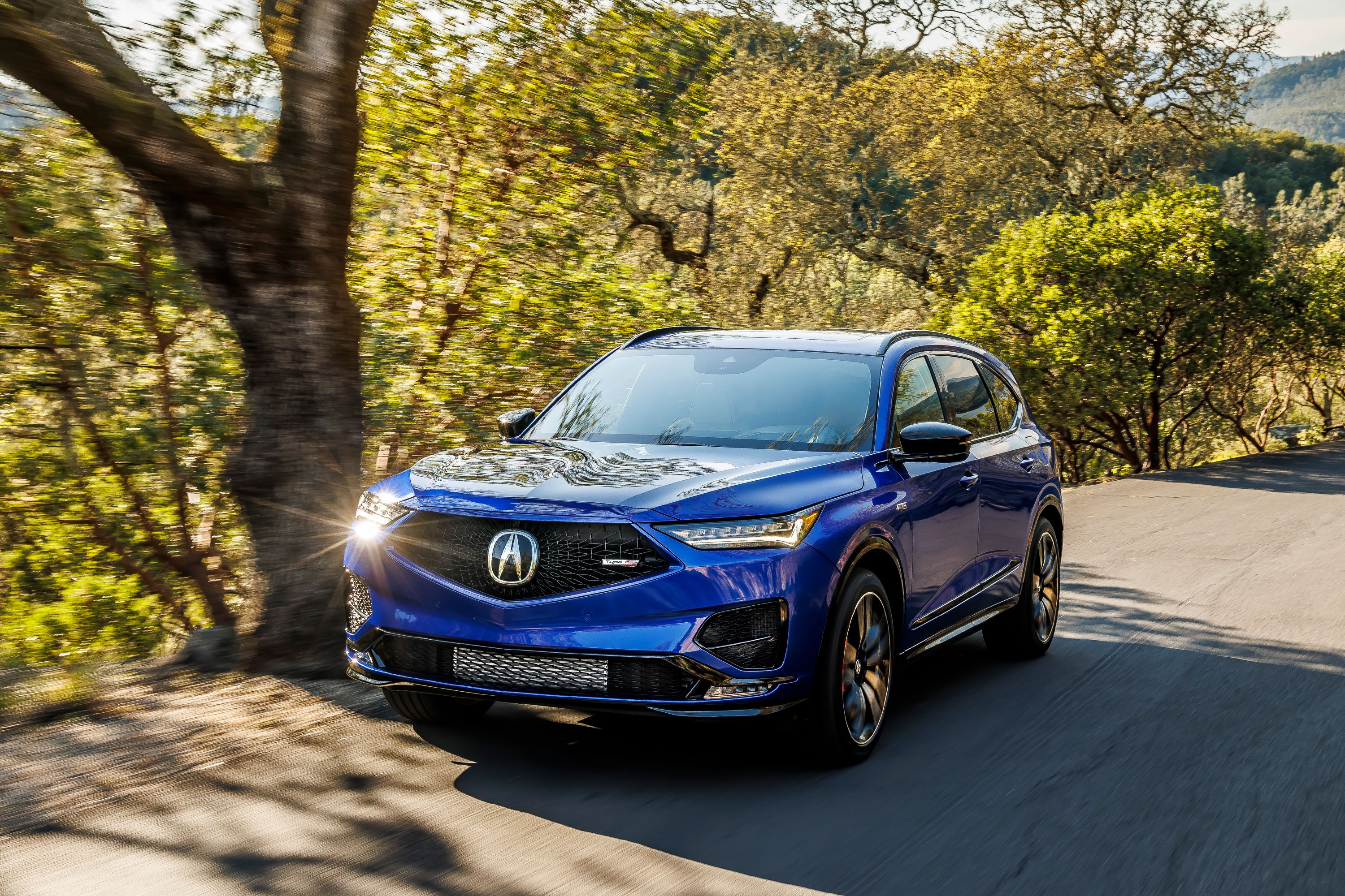 blue 2022 acura mdx type s driving on a road
