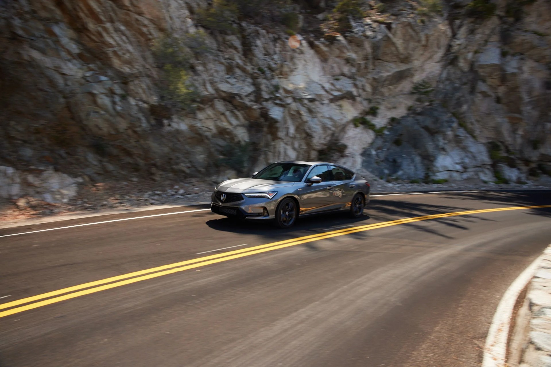 2023 acura integra speeding around a mountain curve