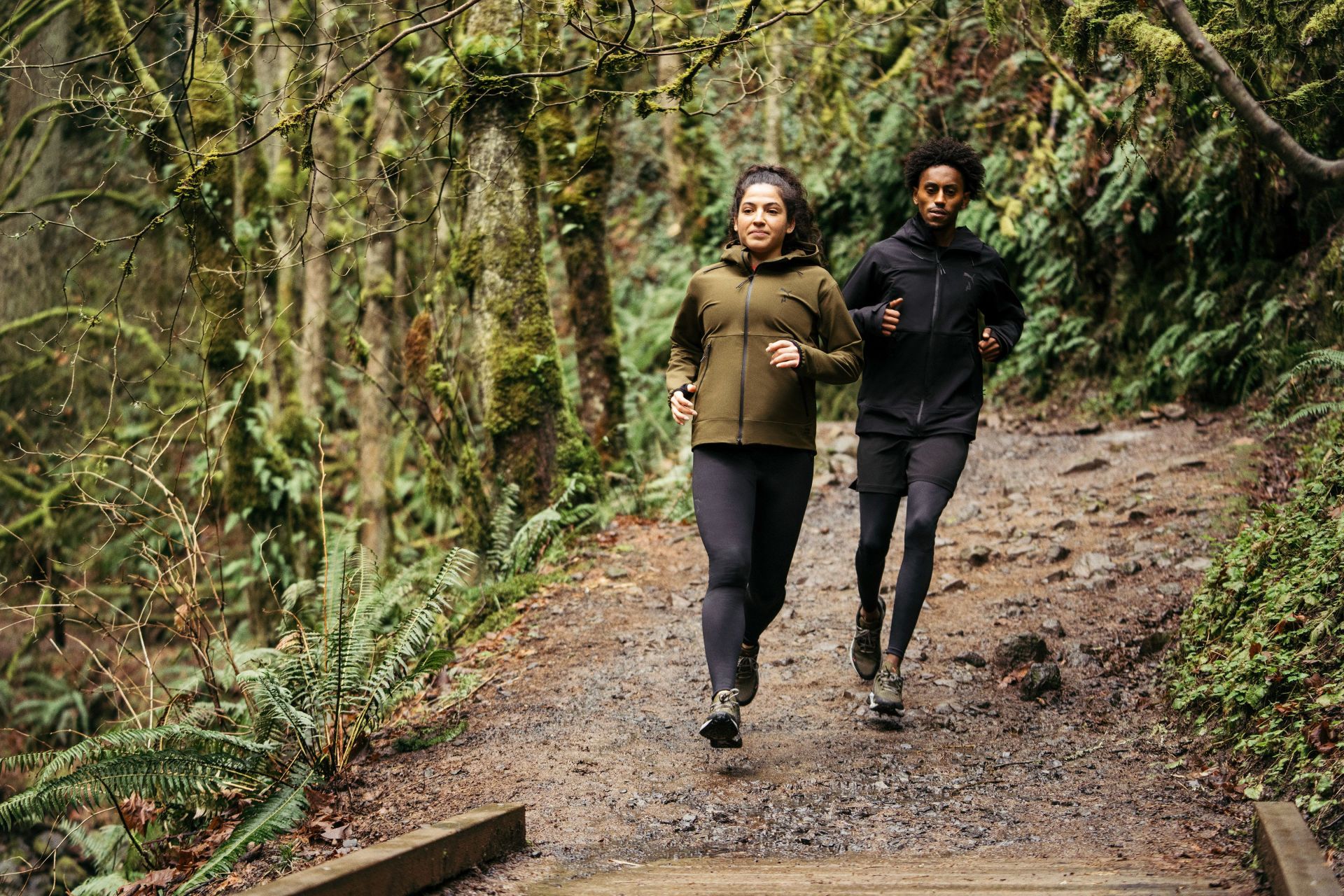 two people running through the woods