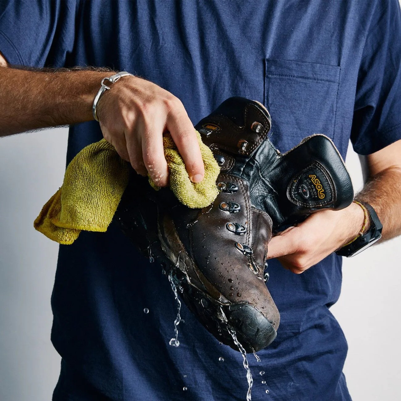 a person washing a leather hiking boot