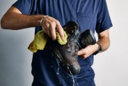a person washing a leather hiking boot