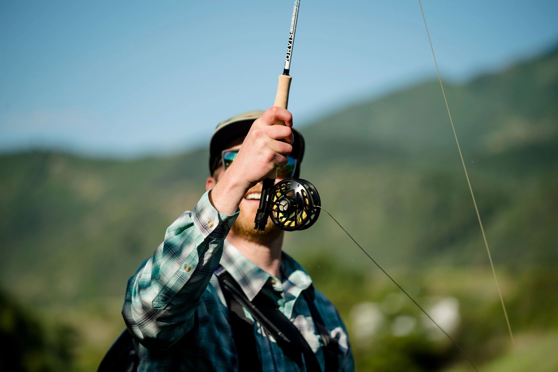 man holding up fishing pole using backcountry gear