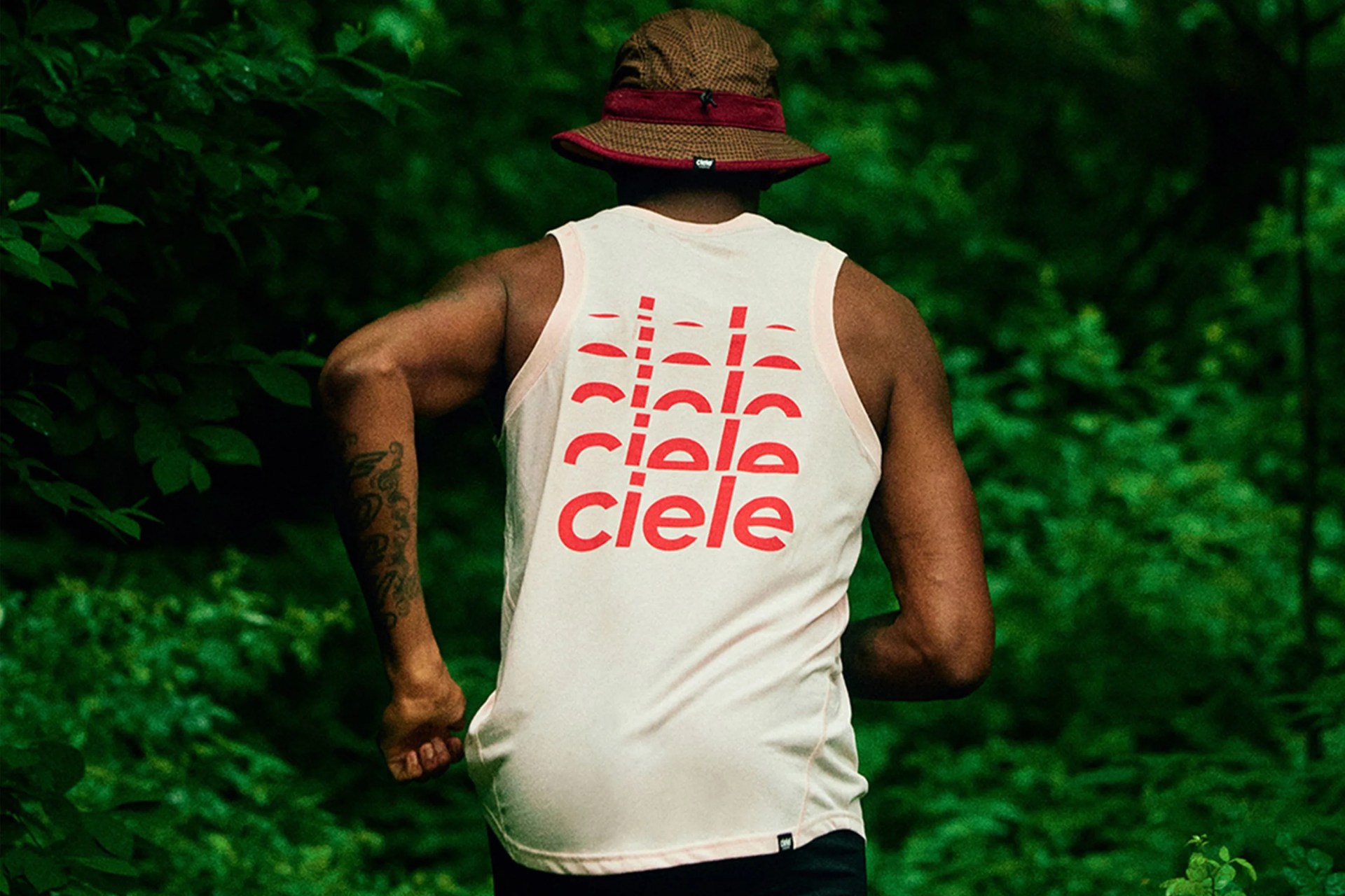 man running with a hat and ciele tank top on
