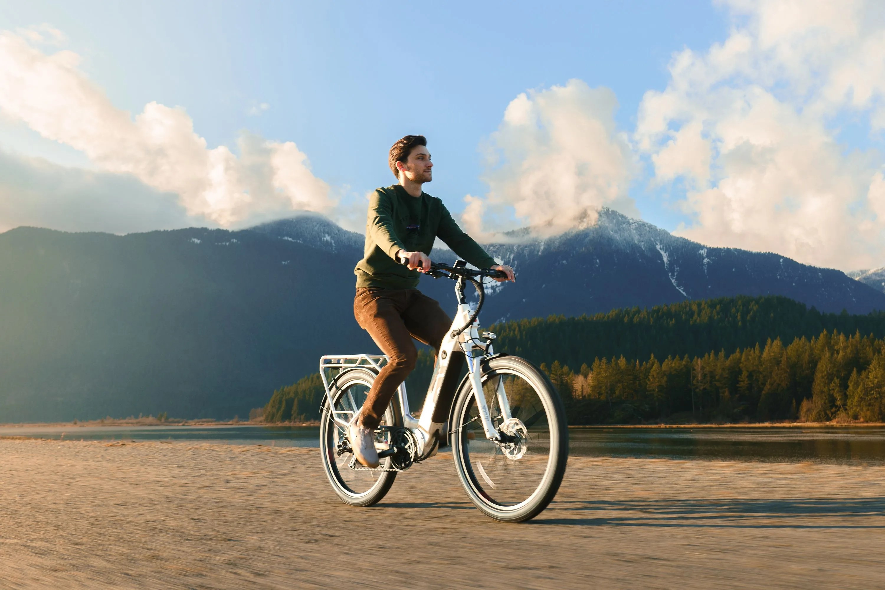 man riding an ebike with a mountain ridge in the background
