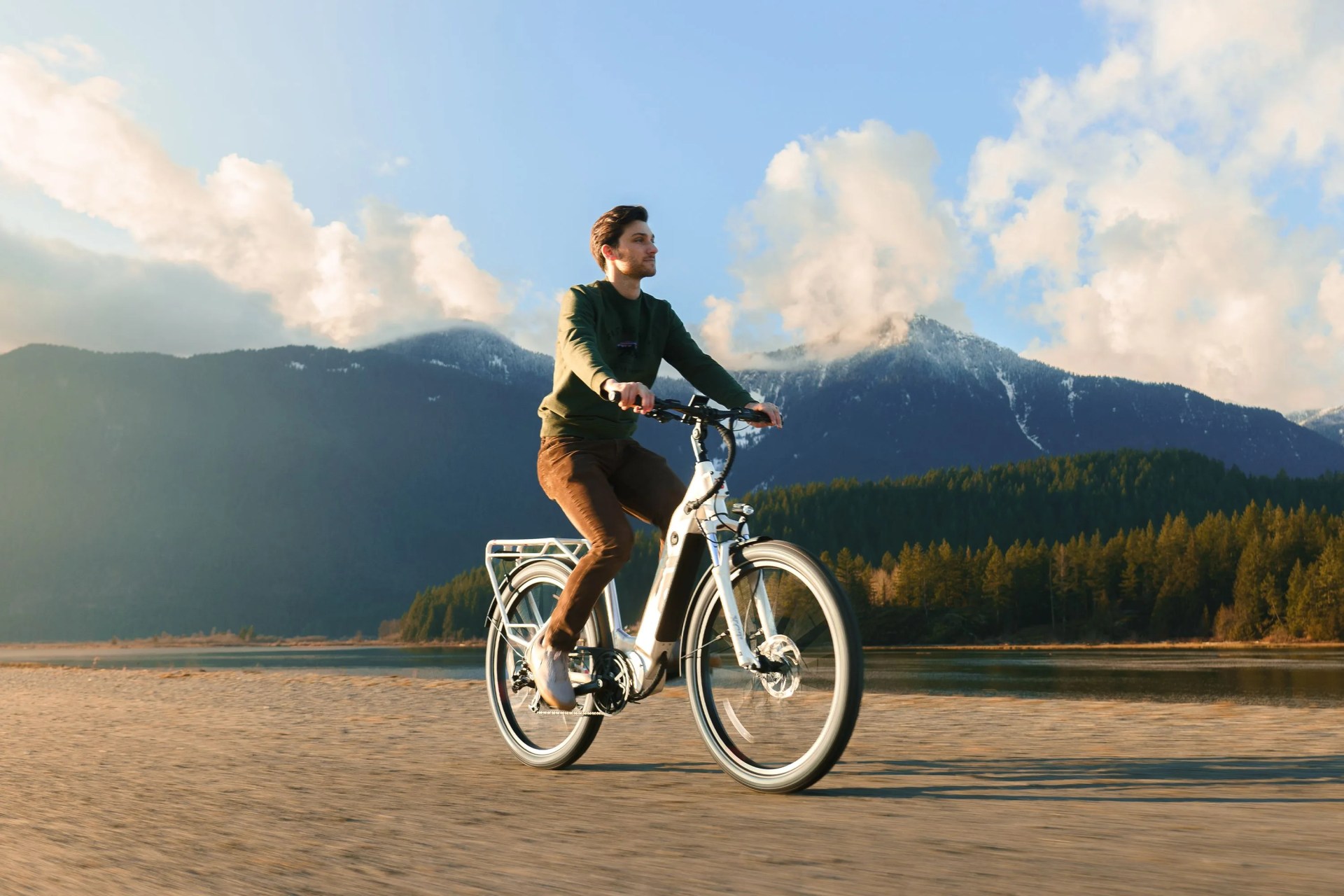 man riding an ebike with a mountain ridge in the background