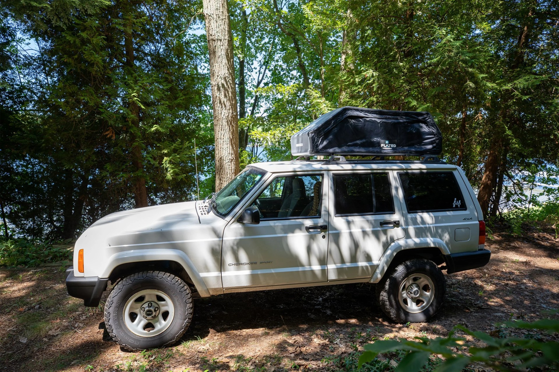 flated air carrier on top of a white jeep cherokee