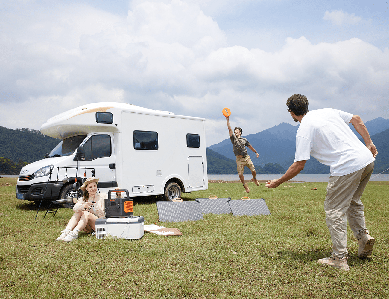 friends play frisbee in front of a jackery solar generator 1000 pro