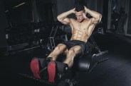 physical athlete exercising with glute ham developer