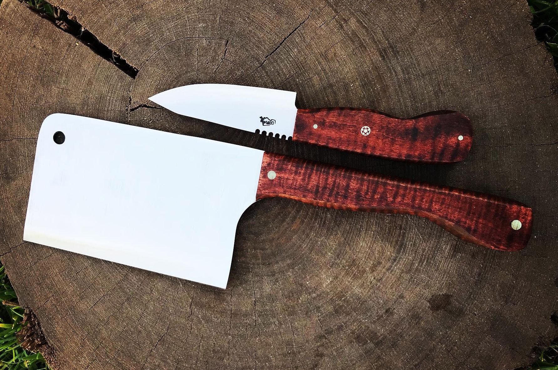 down the river forge knives laying on a tree stump