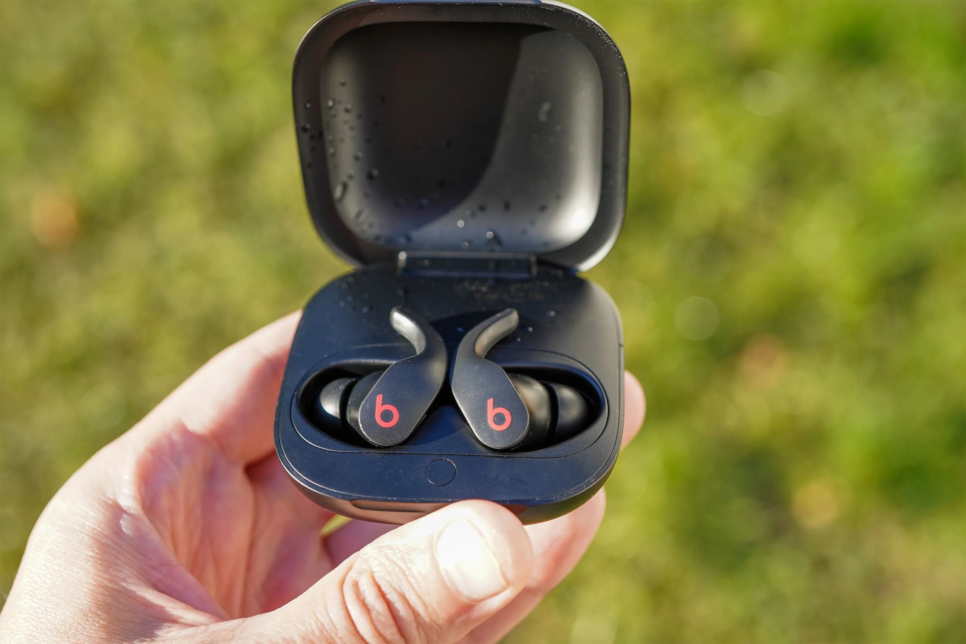 person holding the beats fit pro earbuds