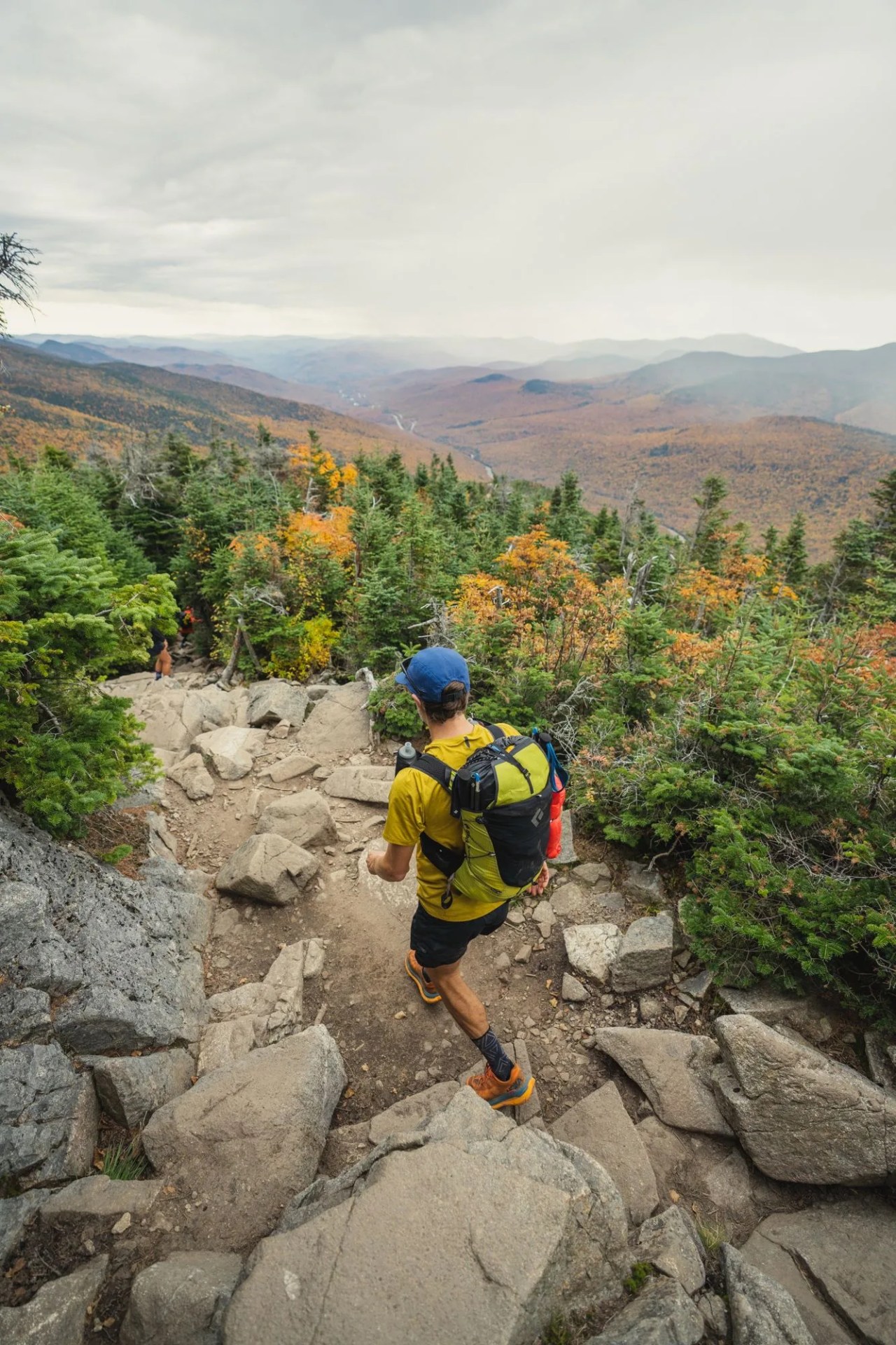 a man hiking on a rocky trail in the mountains