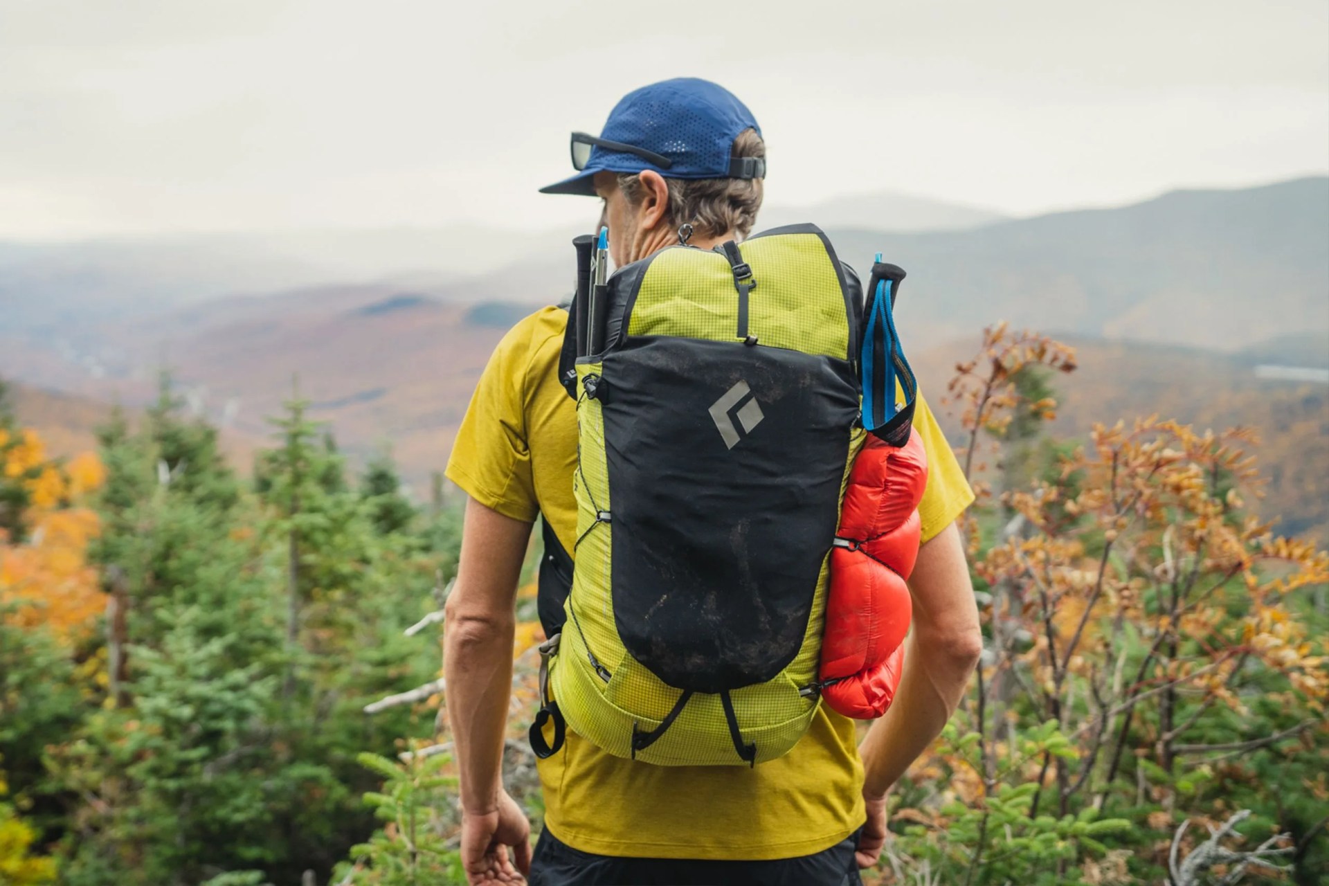 a man wearing a black diamond backpack overlooking a mountain view