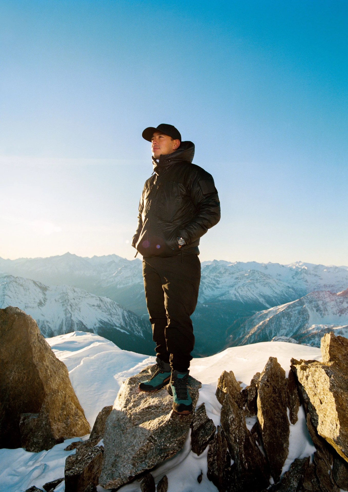 nimsdai purja standing on top of a snowy mountain