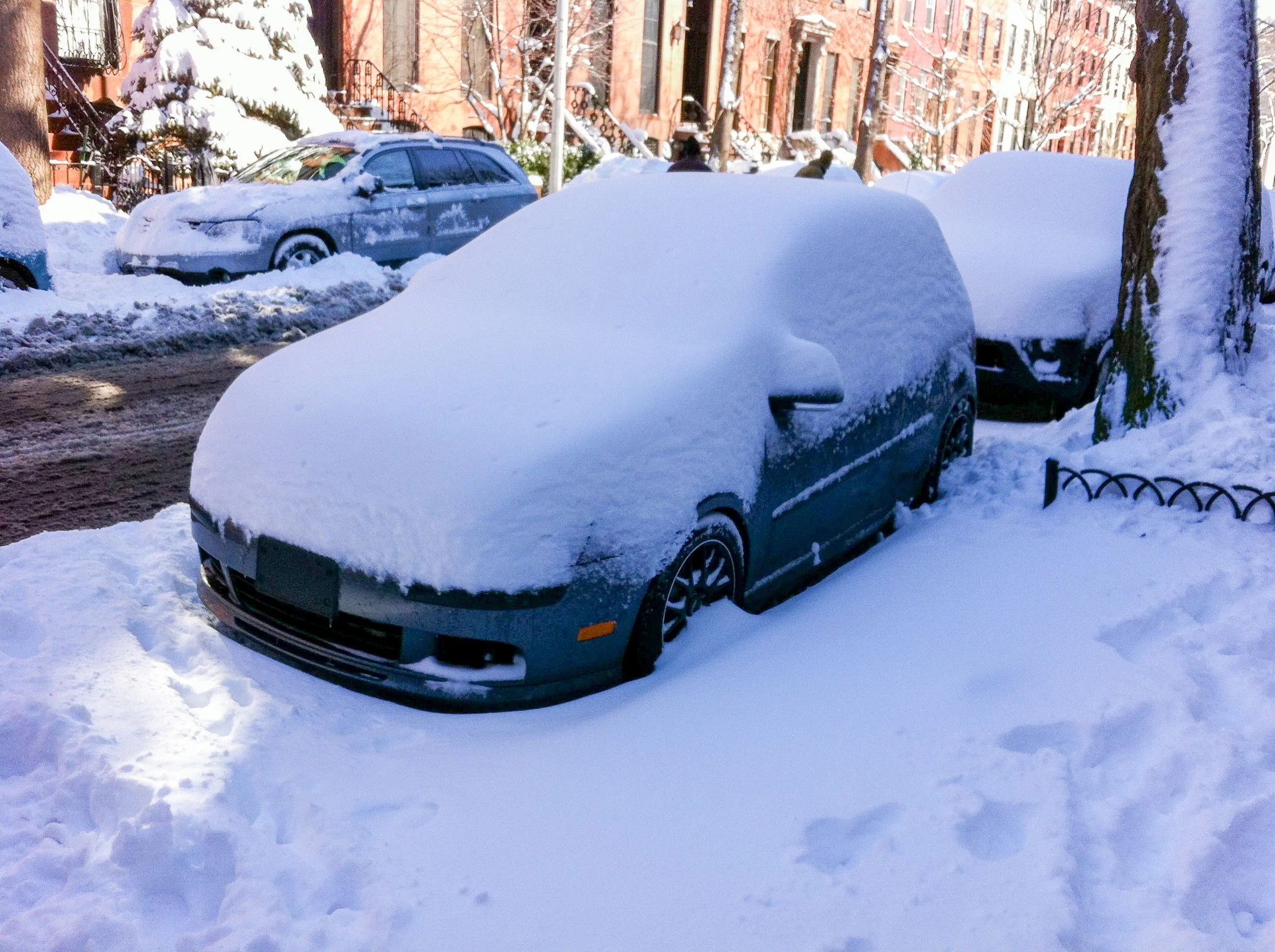 car covered in snow on the side of the road