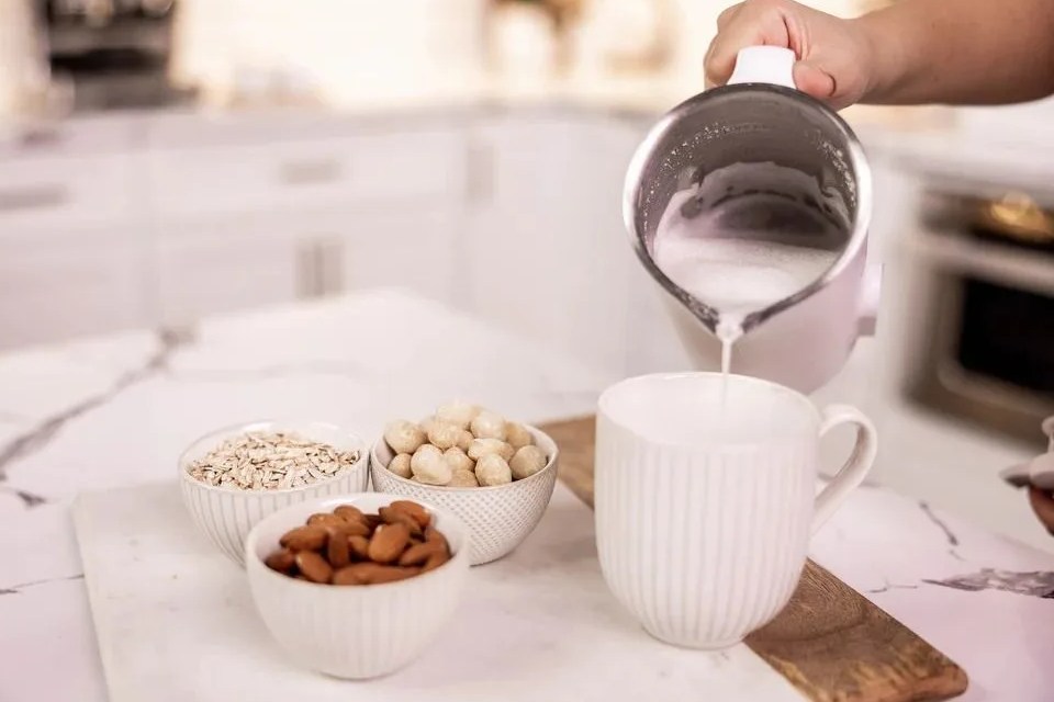 nut milk being poured into a cup from the nutr machine