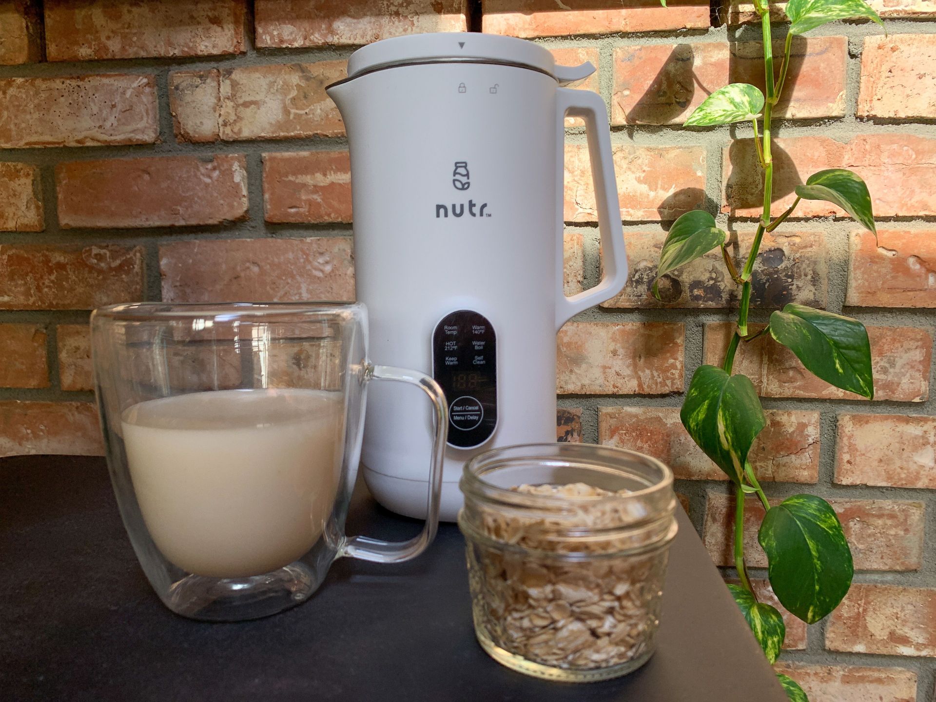 nutr machine with a cup of oat milk and jar of oats