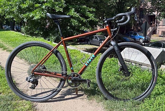 a state bike parked on gravel and grass