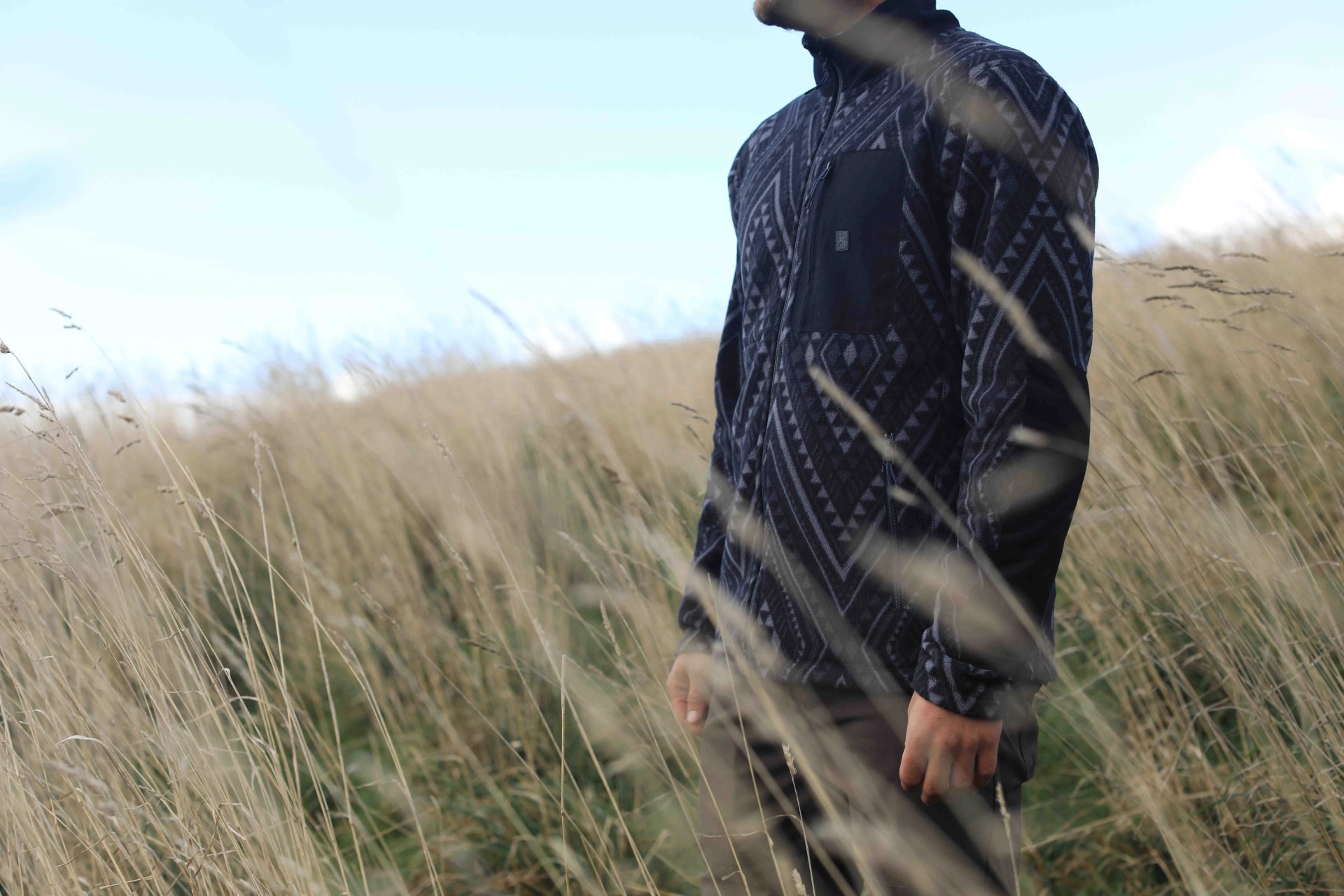 man standing in grassy field wearing roark shirt