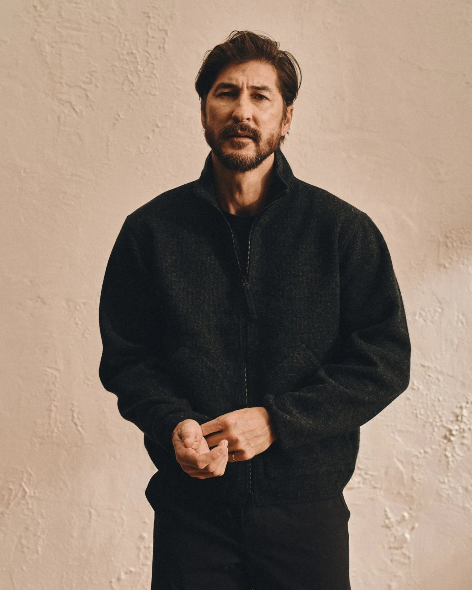 a person wearing a buck mason alpine merino fleece jacket in black