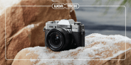 a fujifilm camera sitting on snowy rocks