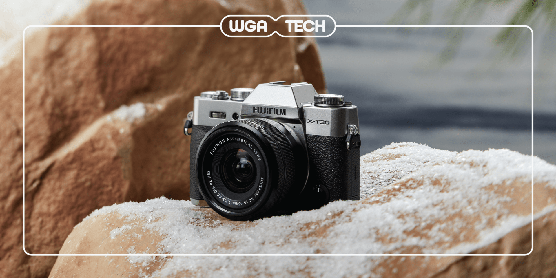 a fujifilm camera sitting on snowy rocks