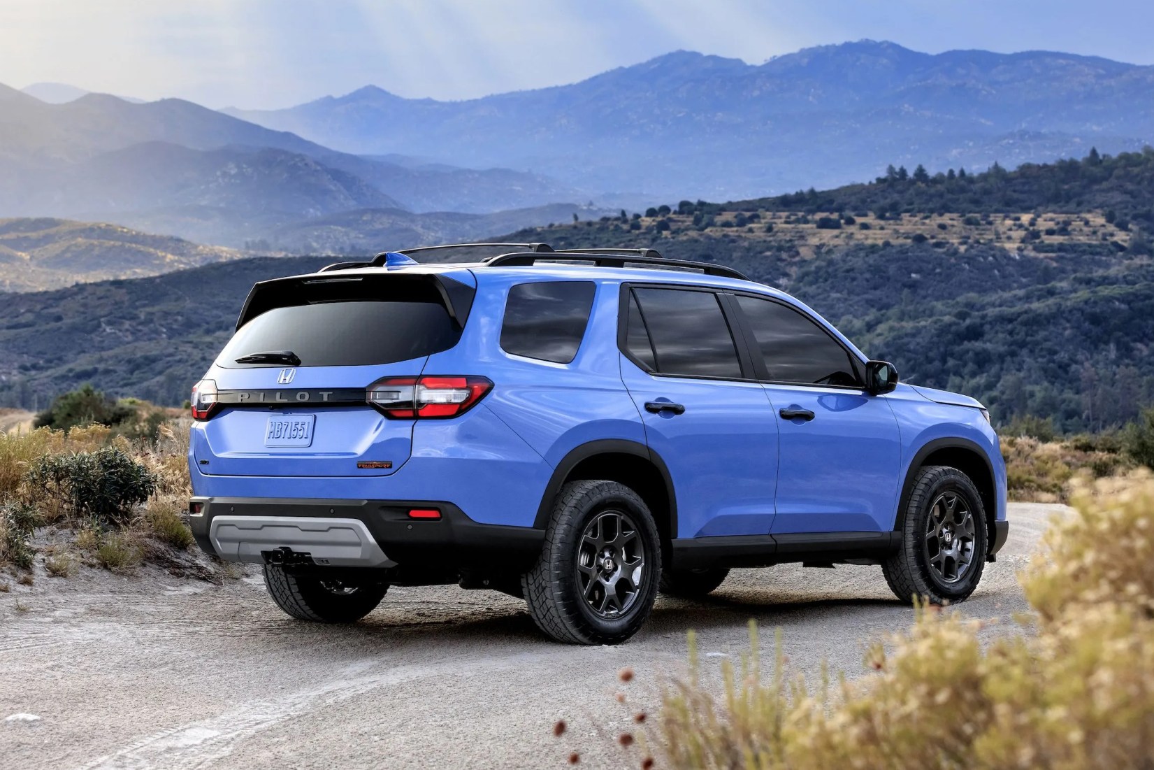 honda pilot trailsport parked on a trail with mountains in the background