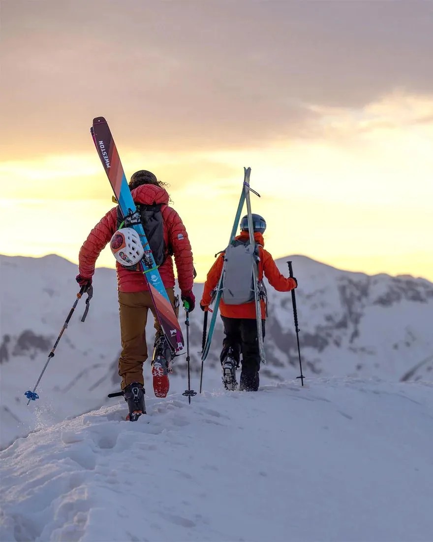 two people climbing a snowy mountain carrying weston skyline carbon skis x vernan kee