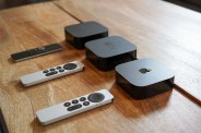 3 apple tv's with remotes on a table