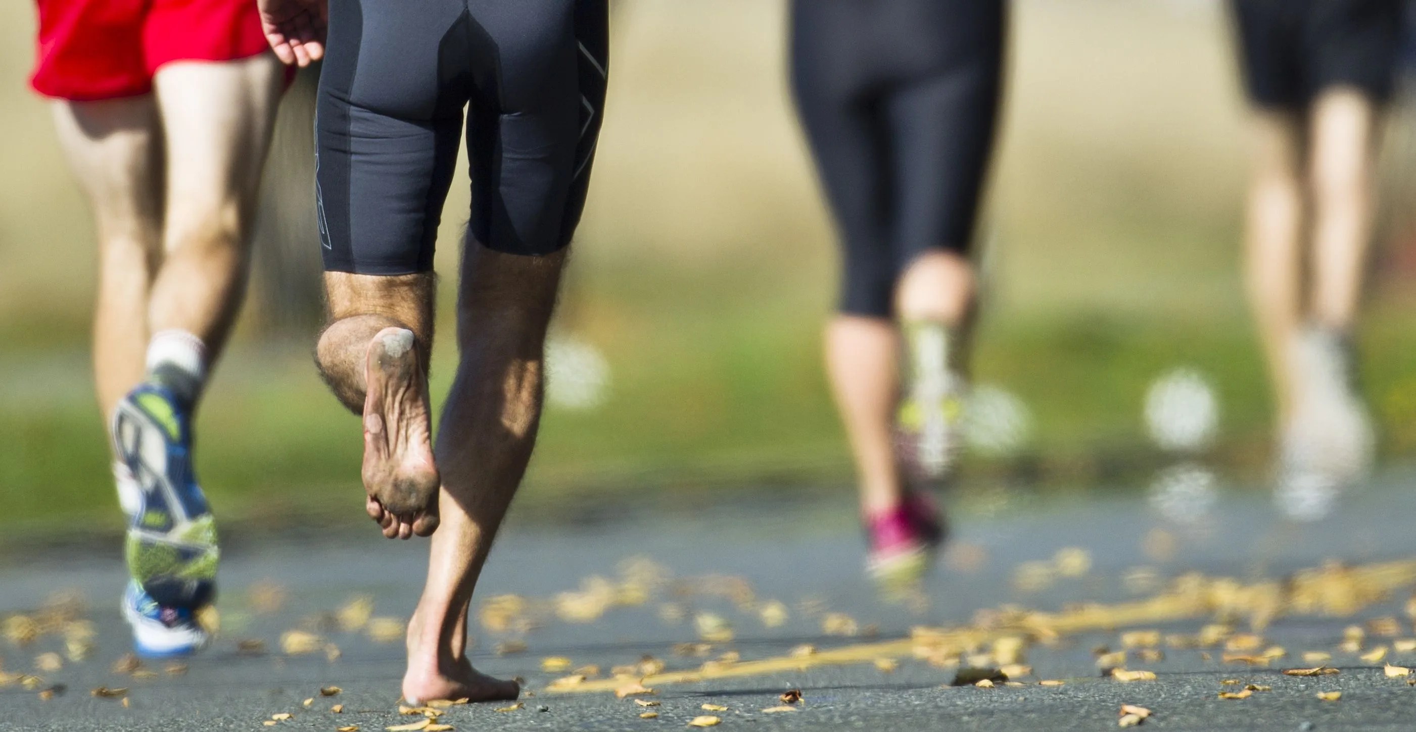 athlete compete in a running race barefoot