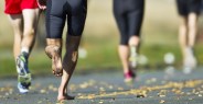 athlete compete in a running race barefoot
