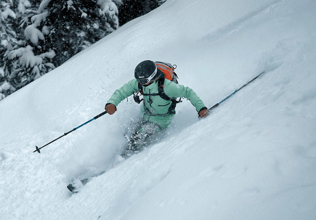 person skiing downhill on snowy mountain