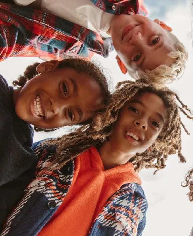 a group of kids smiling while looking down