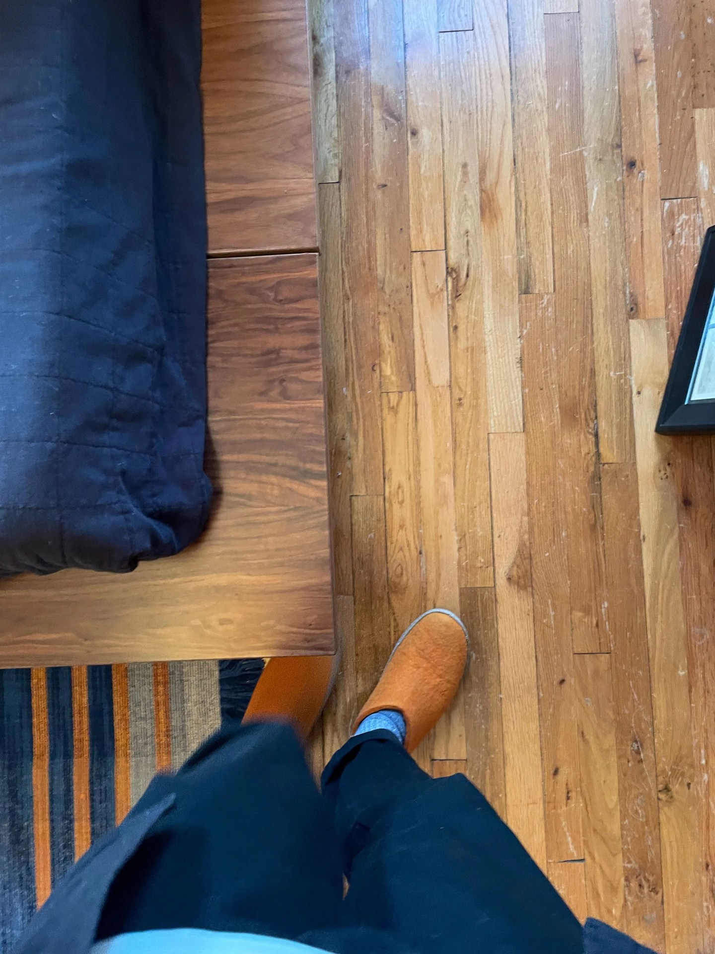 a person standing next to the corner of a floyd bed frame