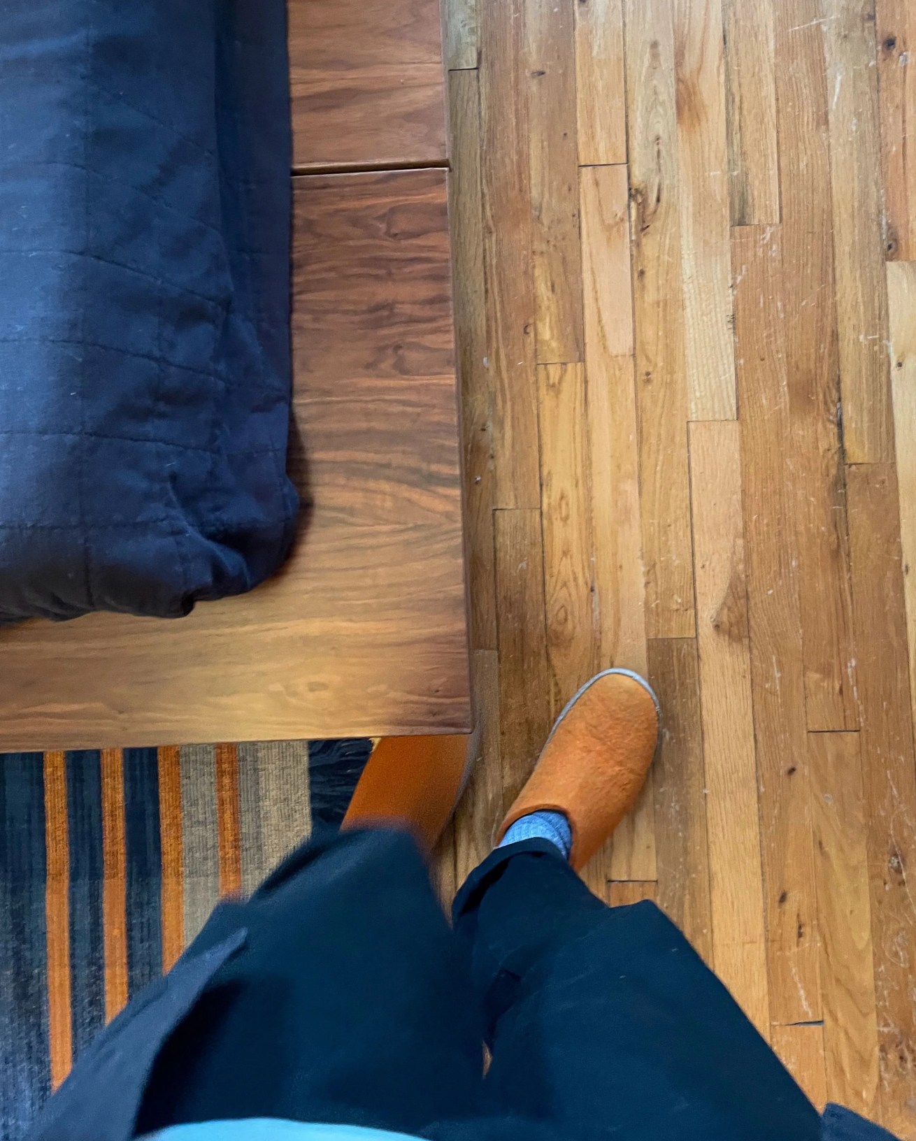 a person standing next to the corner of a floyd bed frame