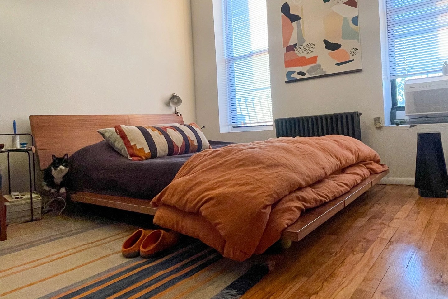 a floyd bed frame with a cat perching by the head board