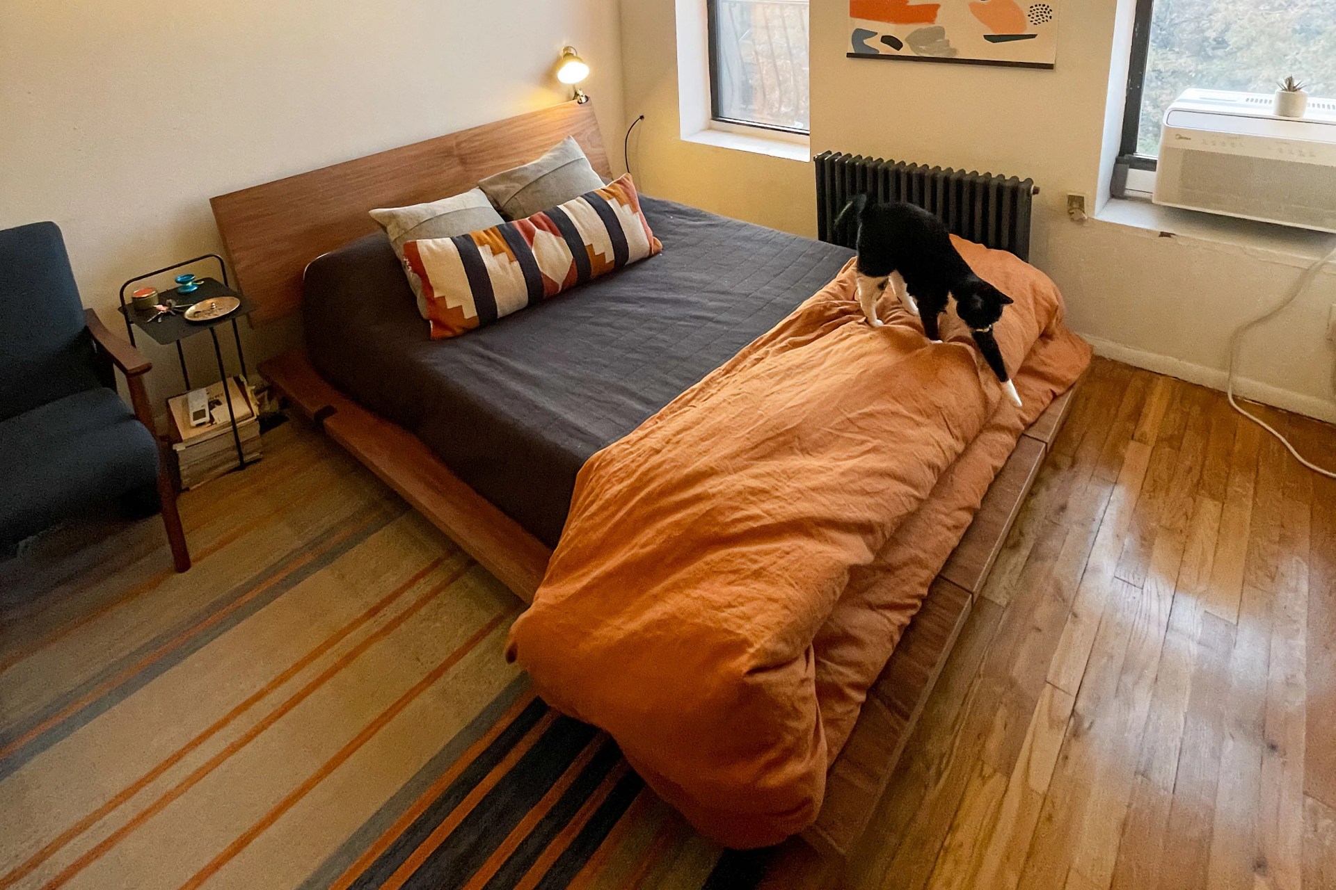 a cat stepping off of a bed