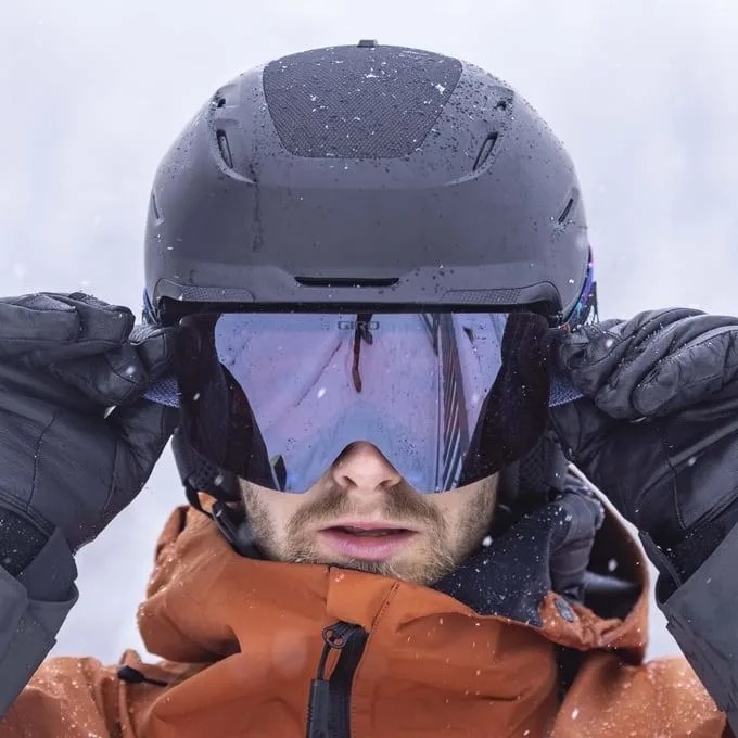 a man wearing a ski helmet and goggles looking at the camera