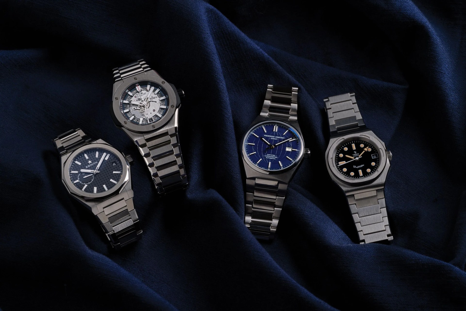 four watches on blue fabric