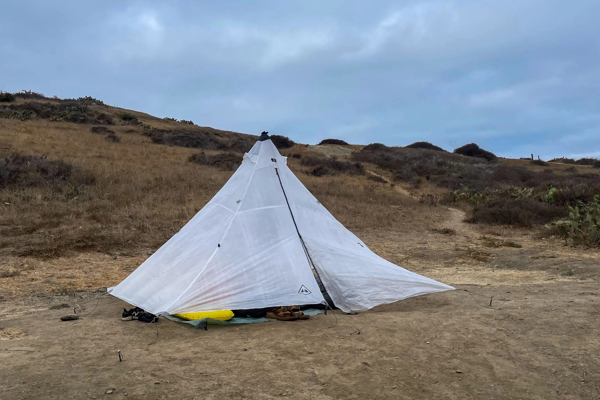 a tent set up off of a dirt trail