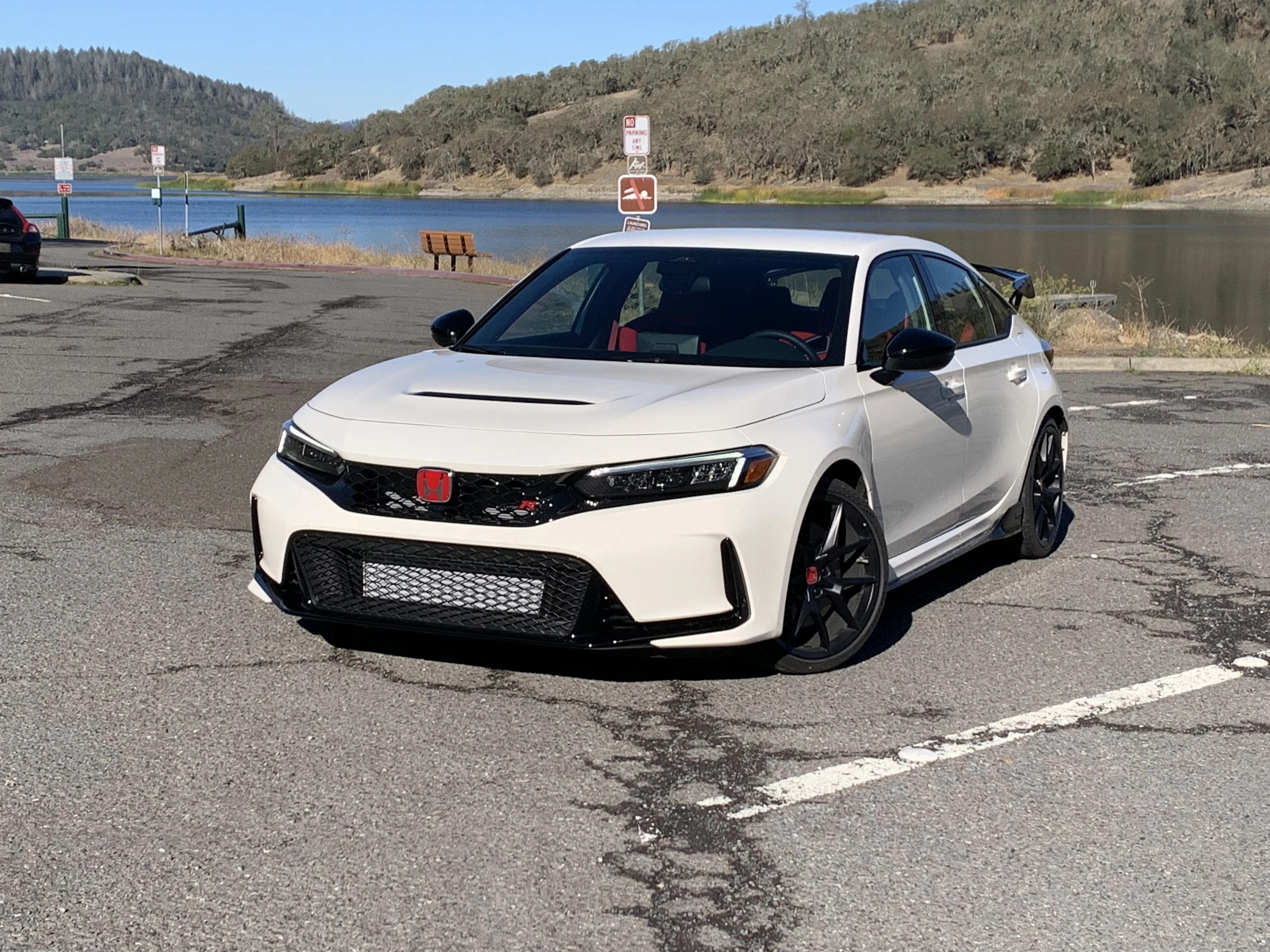 honda civic type r parked in front of a lake