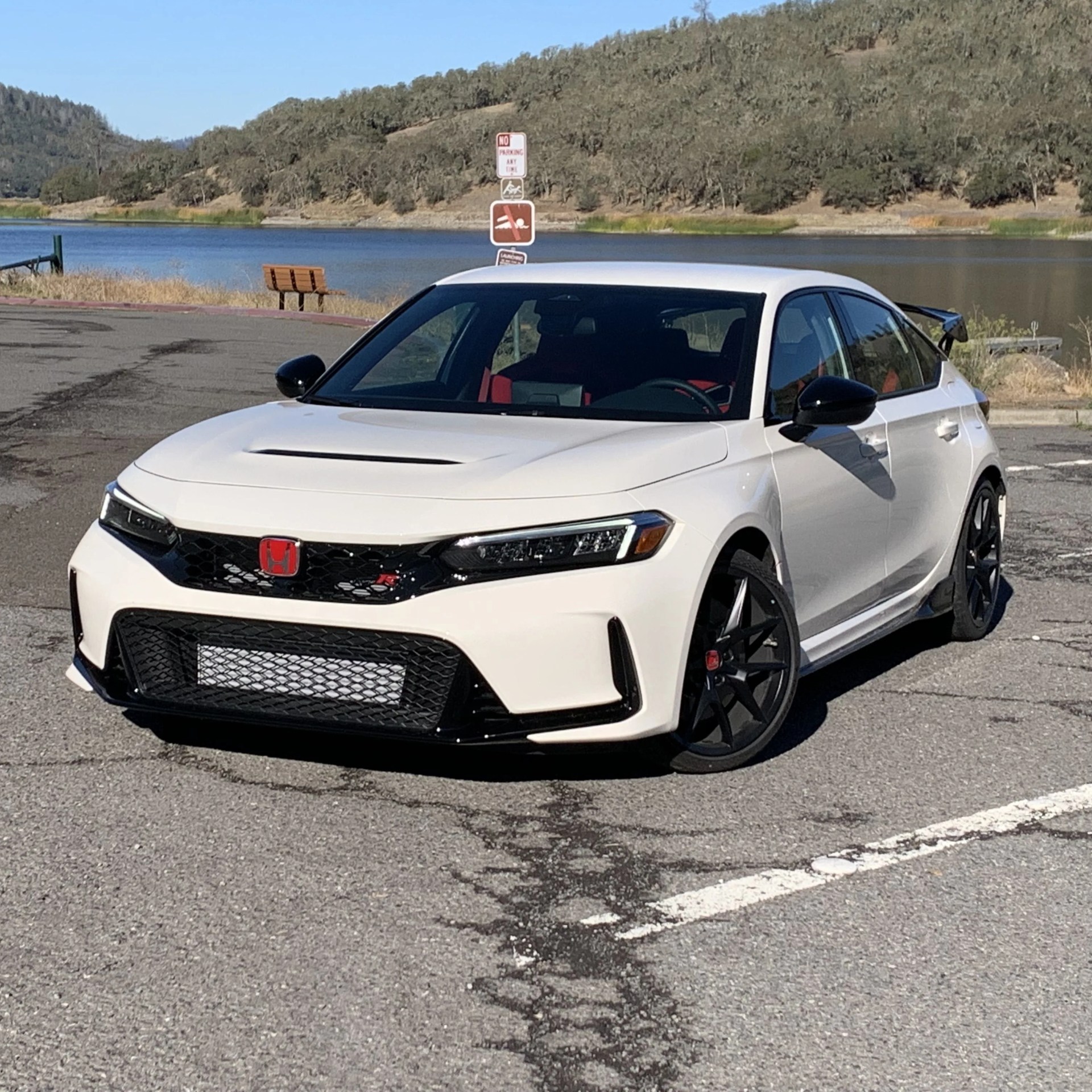 honda civic type r parked in front of a lake