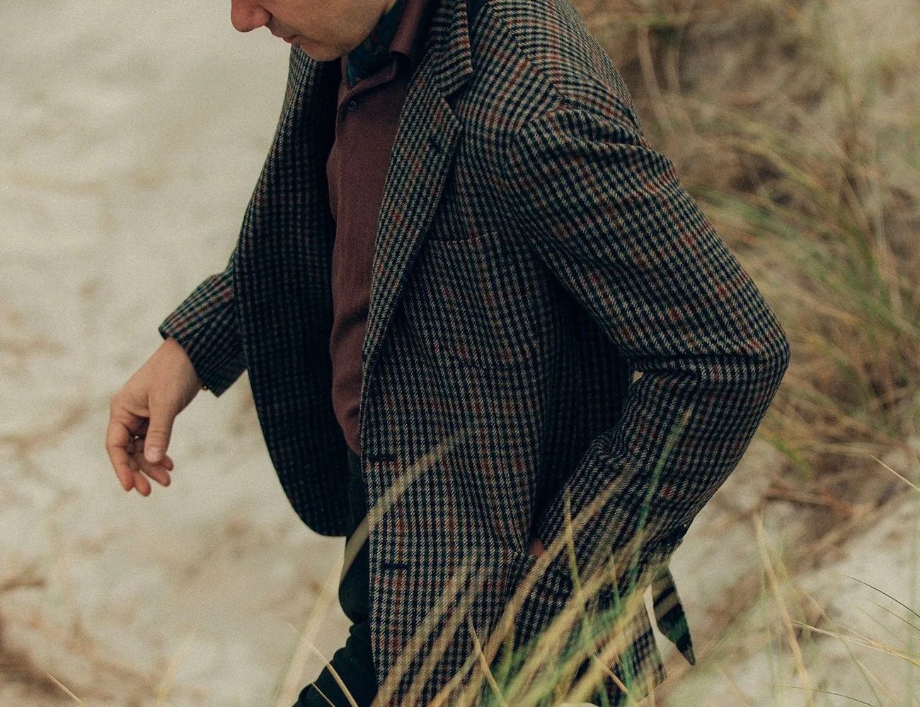 j mueser custom suits man walking through field