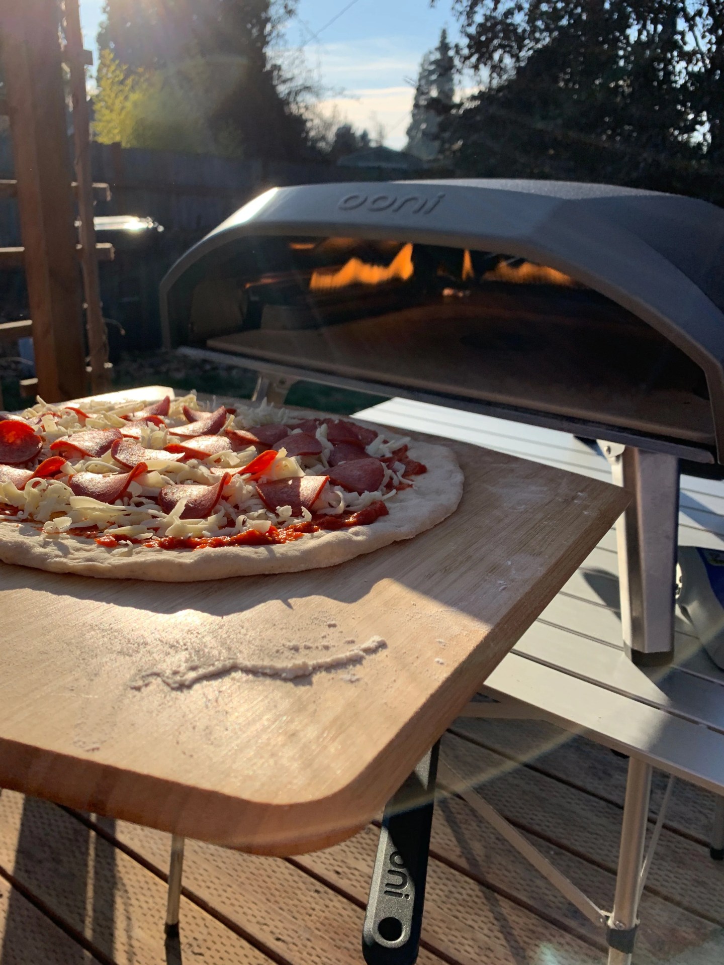 a pizza going into an ooni pizza oven