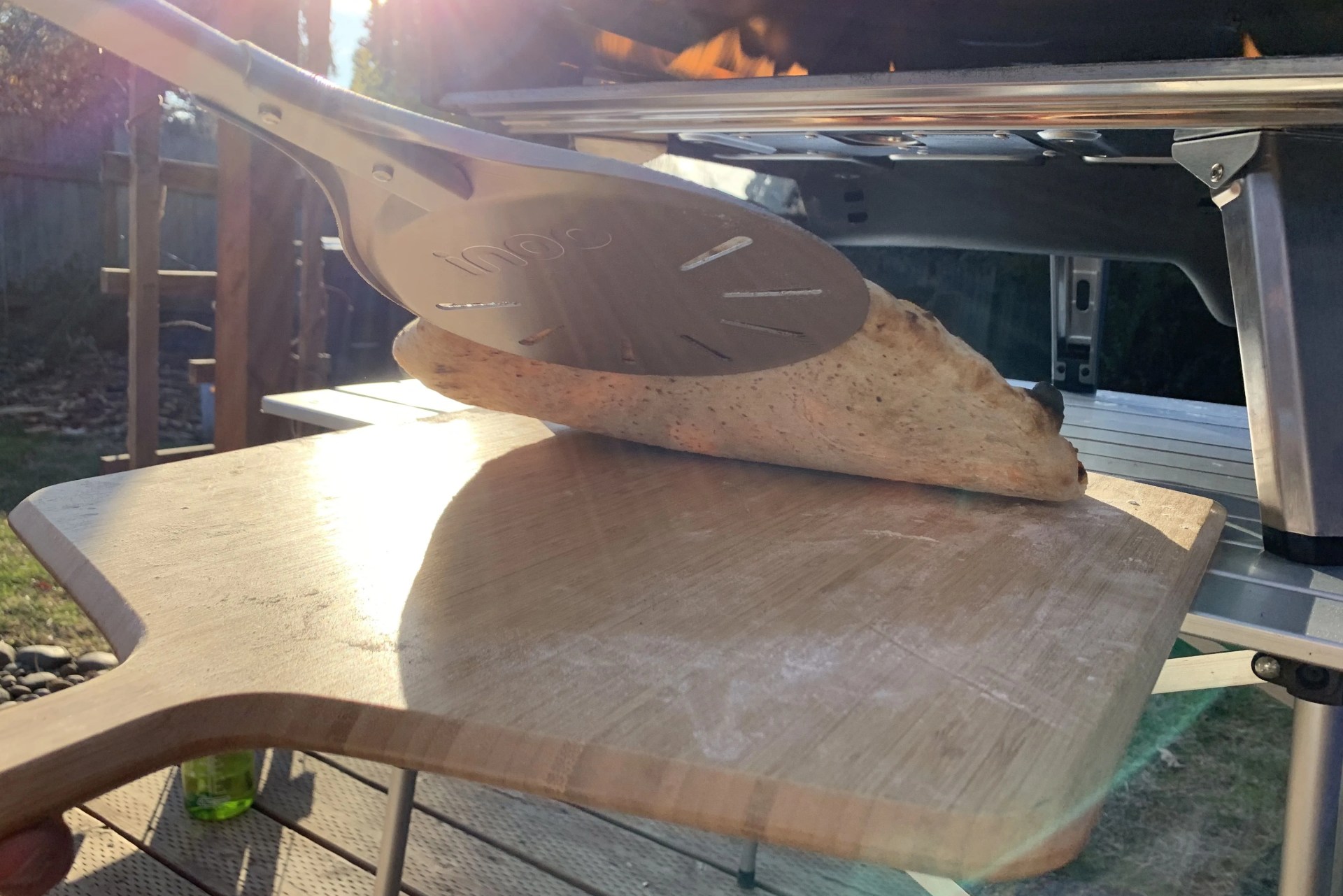 bottom of a pizza coming out of a pizza oven