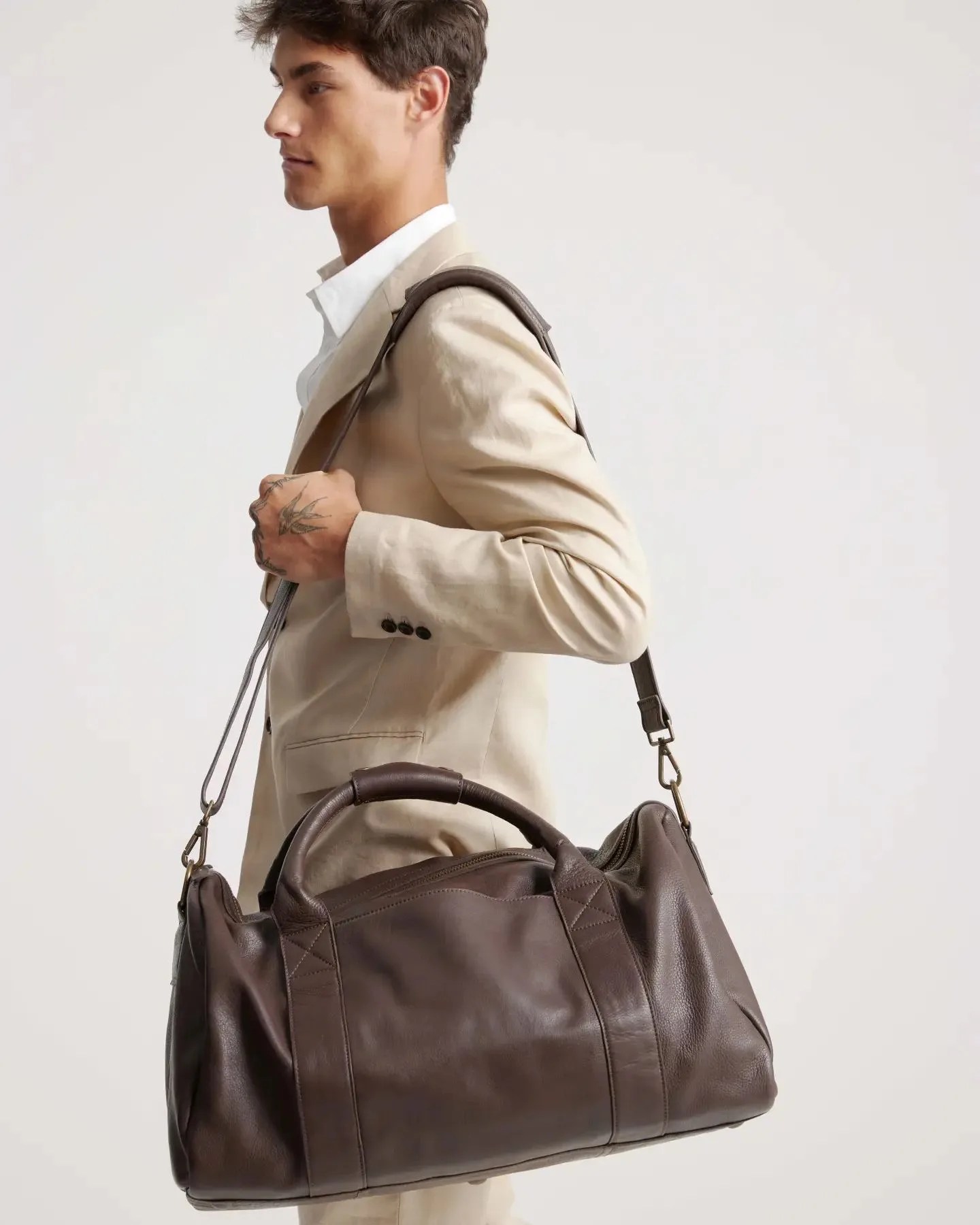 man carrying quince nappa leather duffle bag