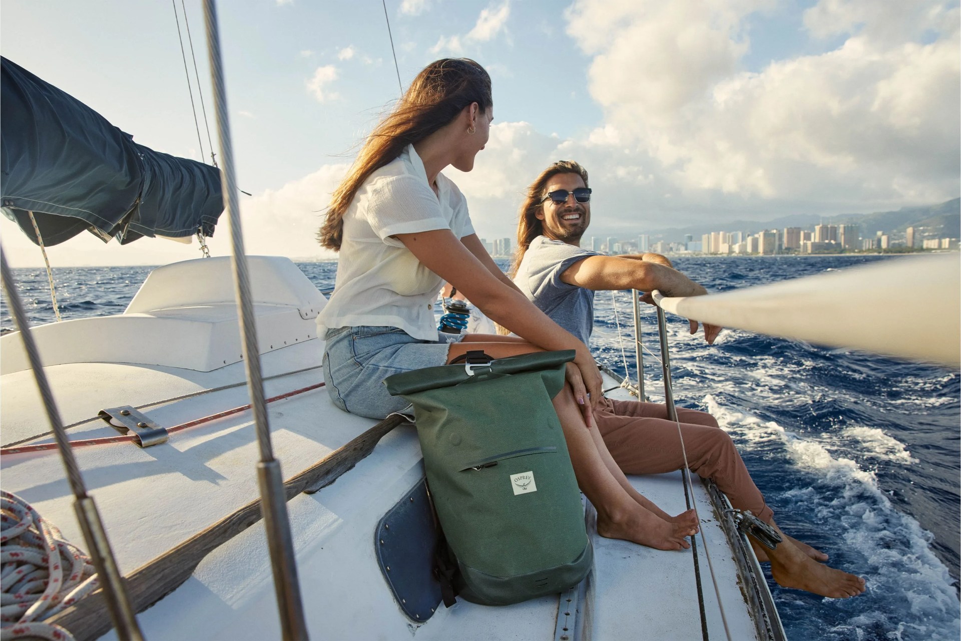 a couple on a sail boat with an osprey bag