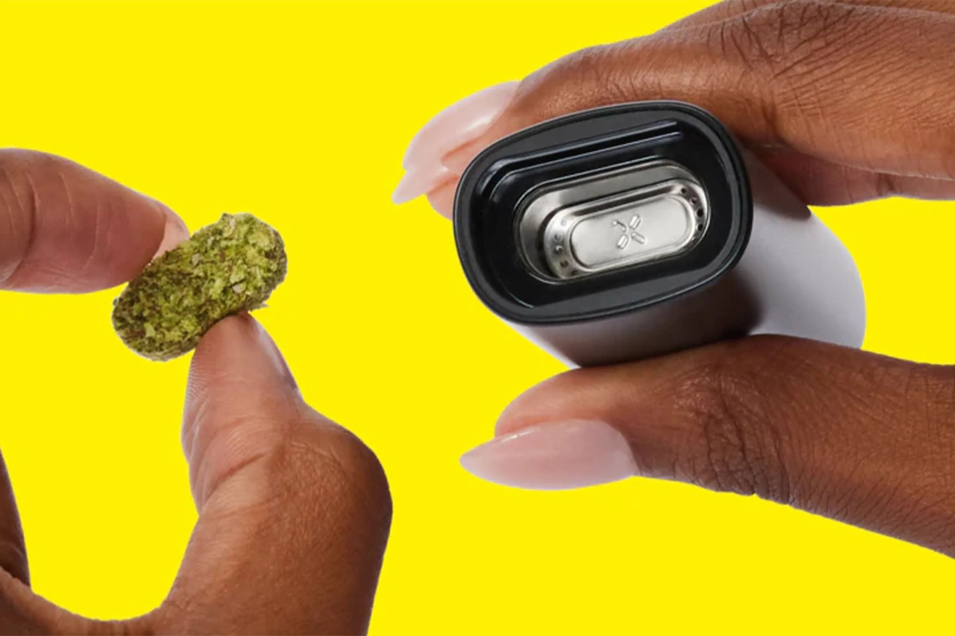 hands putting weed flower into a pax vape pen