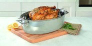 a roasted turkey sitting in a pan on a counter