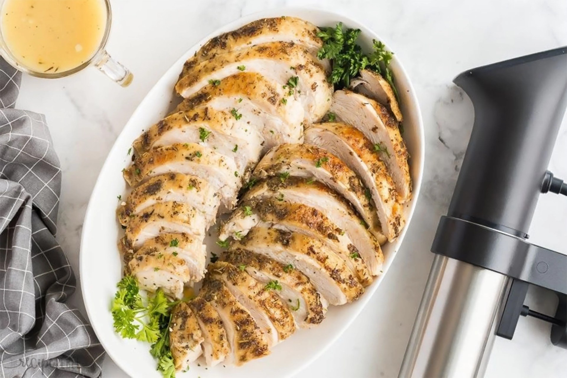 a plate of cooked turkey next to a sou vide machine
